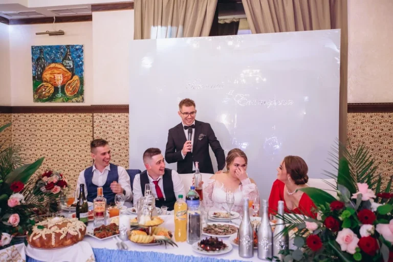 Коровай на весільному столі перед молодятами, ведучий Іван Панов з мікрофоном