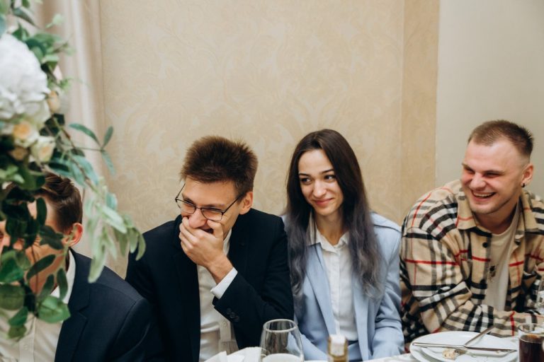 Компанія гостей сміється за столом