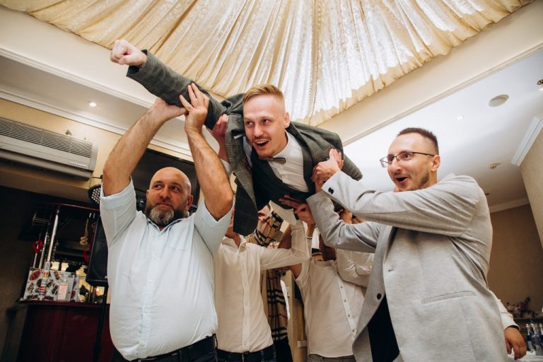 Гості піднімають чоловіка на руки під час свята