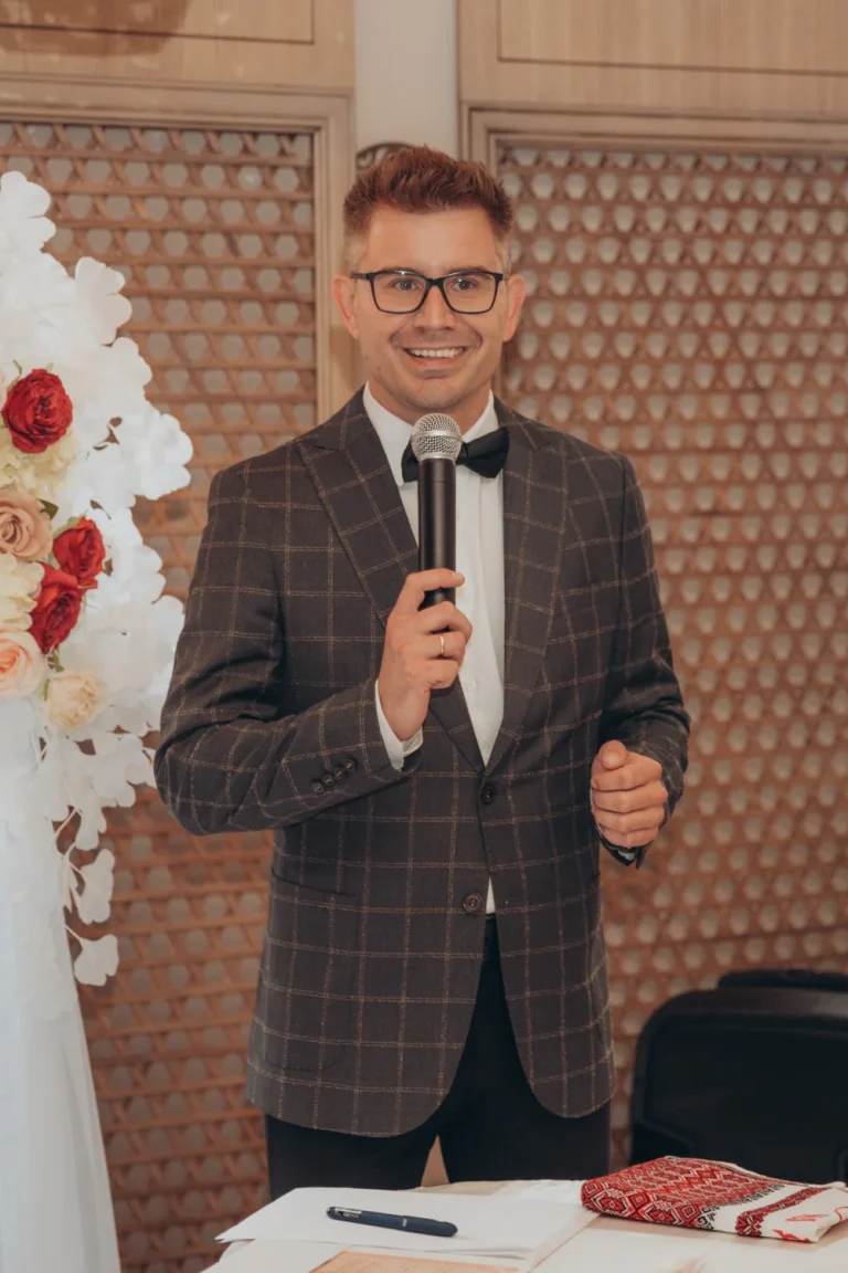 Ведучий Іван Панов з мікрофоном, весільний рушник на столі